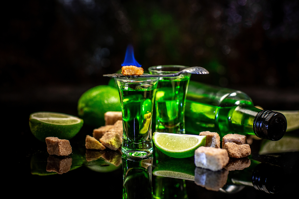 Alcoholic drink, creative stimulant and bohemian lifestyle concept theme with. green bitter wormwood tincture in glasses